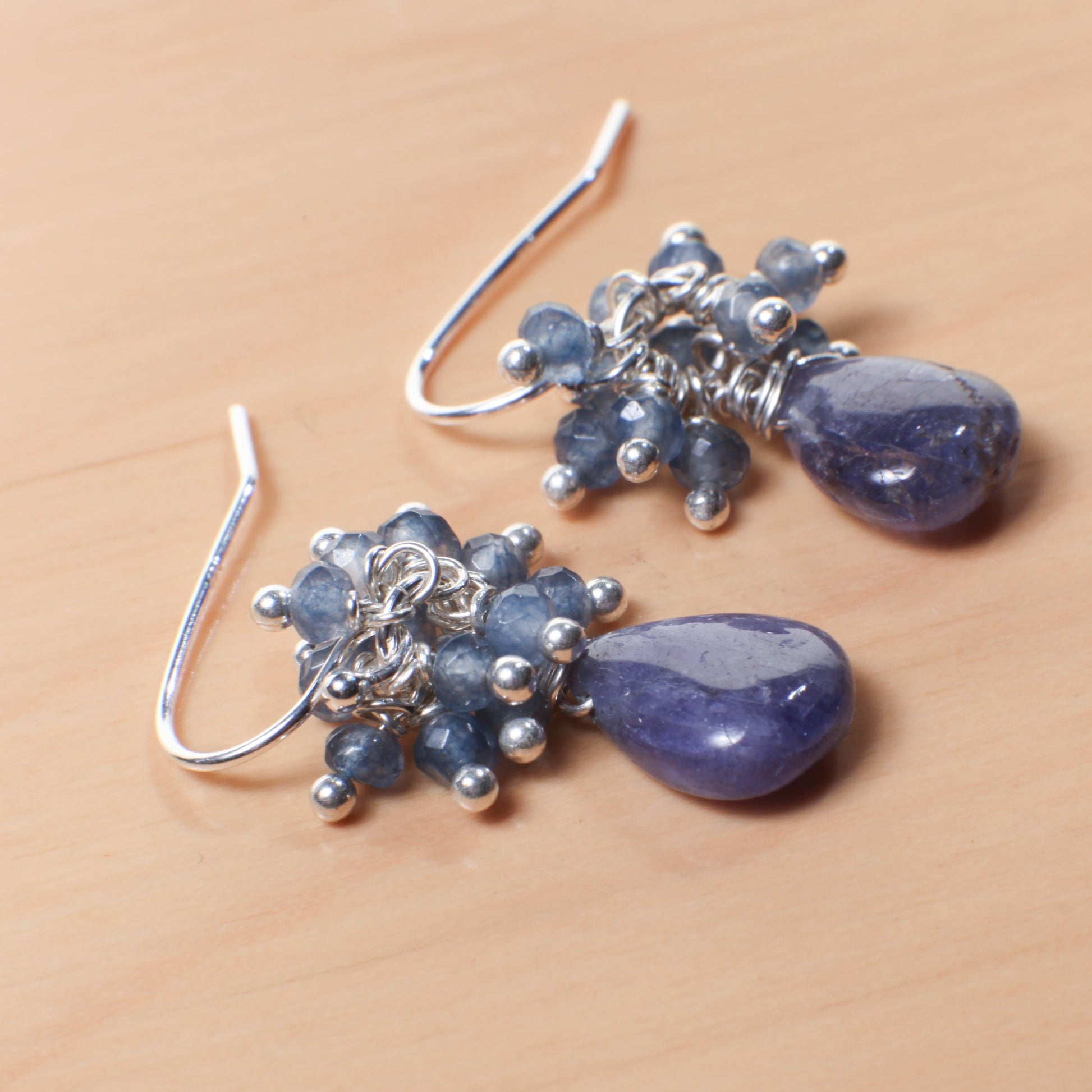 May include: A pair of silver dangle earrings with blue teardrop shaped stones and blue and silver beads